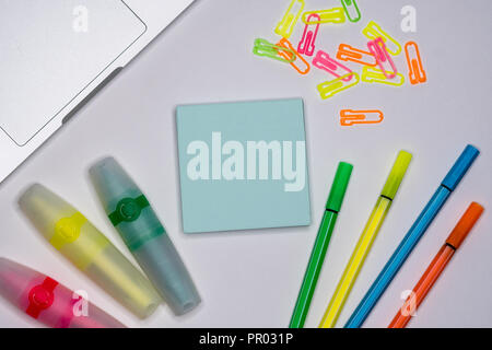 Sticky Notes con pennarelli, penne colorate, fermagli per carta posa su un tavolo, torna a scuola, scuola e forniture per ufficio. Foto Stock