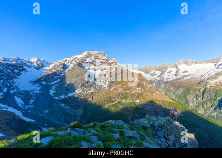 Un escursionista guarda al monte Disgrazia dal di sopra, Chiareggio valley, Valmalenco, Valtellina, Lombardia, Italia, Europa Foto Stock