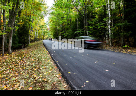 Car guida attraverso la strada d'autunno Foto Stock