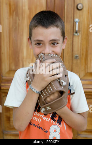 Ritratto di un giovane ragazzo di ridere a giocare a baseball nelle strade di Santiago de Cuba Caraibi del Nord America Foto Stock