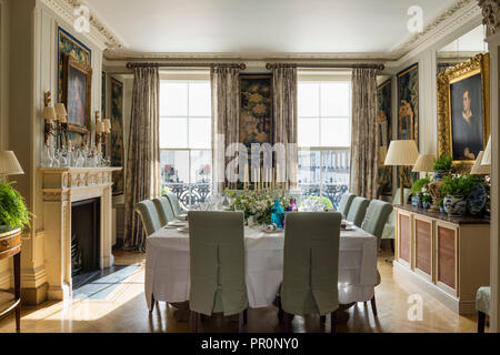 Square tavolo da pranzo con grandi finestre a ghigliottina di slittamento e sedie, secolo XIX verdure arazzo pannelli Foto Stock