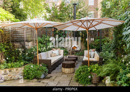 Londra giardino cortile recintato con trellis all'ombra di ombrelloni Foto Stock