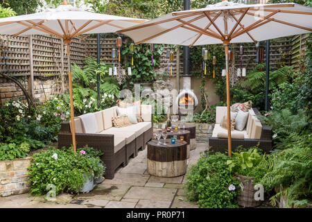 Londra giardino cortile recintato con trellis all'ombra di ombrelloni Foto Stock