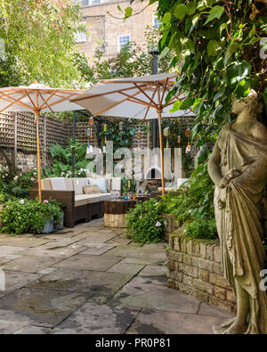 Giardino scultura in Londra giardino cortile recintato con traliccio e ombreggiata con ombrelloni Foto Stock