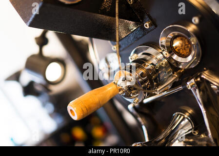 La tostatura del caffè macchina vicino up shot con vedendo i chicchi di caffè. Foto Stock