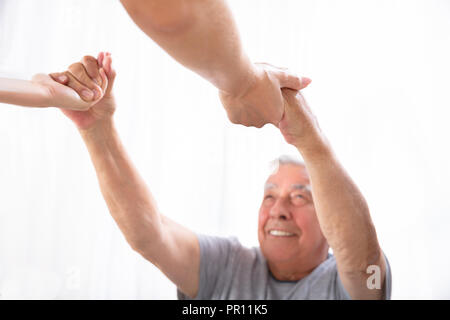 Close-up di una figlia per mano di suo padre Felice Foto Stock