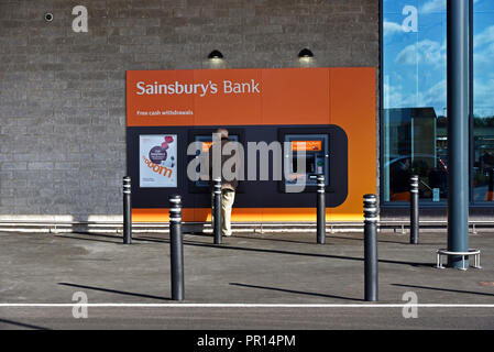 Sainsbury's Bank. Il prelievo gratuito di denaro contante. Cliente al bancomat. Sainsbury's e Argos supermercato. Shap Road, Kendal Cumbria, Inghilterra. Foto Stock