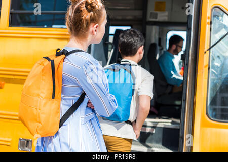 Carino piccolo alunni inserimento scuola bus con bella driver per adulti Foto Stock