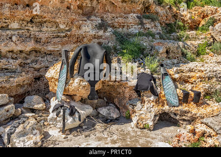 Parti bagnate di attrezzatura subacquea essiccazione al sole sulle rocce Foto Stock