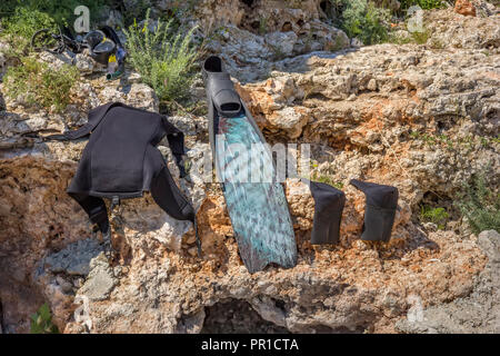 Parti bagnate di attrezzatura subacquea essiccazione al sole sulle rocce Foto Stock