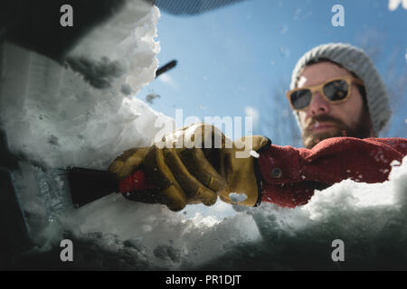 Uomo di neve di pulizia dal parabrezza per auto Foto Stock