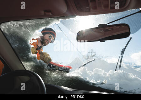 Uomo di neve di pulizia dal parabrezza per auto Foto Stock