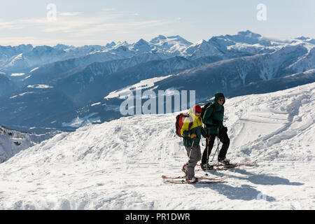 Maschio e femmina gli sciatori a camminare su una montagna innevata Foto Stock