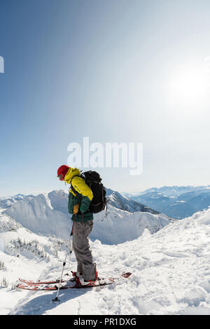 Sciatore in piedi su una montagna innevata Foto Stock