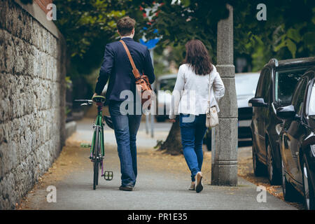 Colleghi di lavoro a camminare sul marciapiede in città Foto Stock