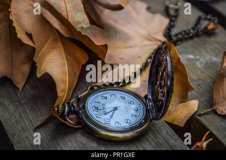 Orologio da tasca su foglie di autunno Foto Stock