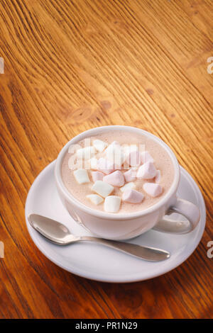 Tazza di calda fresca bevanda al cioccolato con marshmallow sul tavolo di legno, vista dall'alto Foto Stock