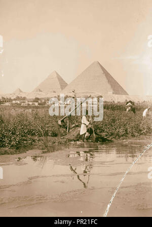 Piramidi di Giza. Le tre piramidi con 'shaduf' in primo piano. 1934, Egitto, Jīzah, Jizah Foto Stock