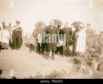 Gli uomini e le donne, comprese eventualmente Winston Churchill e Herbert Samuel, in un cimitero militare con il clero cristiano. 1921 Foto Stock