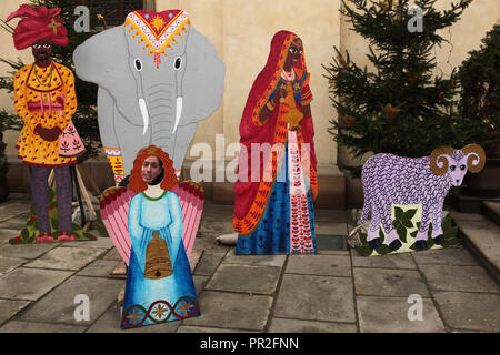 L'uomo guarda fuori dalla figurina di un angelo nel presepe di fronte alla chiesa di Santa Maria della Vittoria (Kostel Panny Marie Vítězné) nel Quartiere Piccolo (Malá Strana) a Praga, Repubblica Ceca. Foto Stock