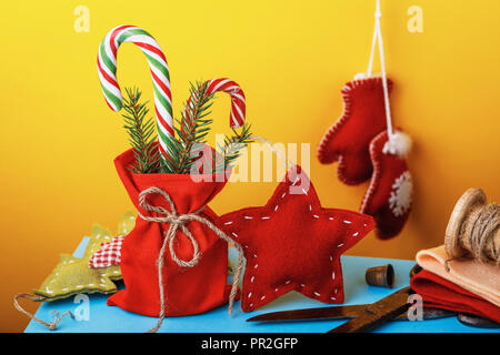 Le decorazioni di Natale e doni fatti da mani proprie. Festive giocattoli su sfondo colorato Foto Stock