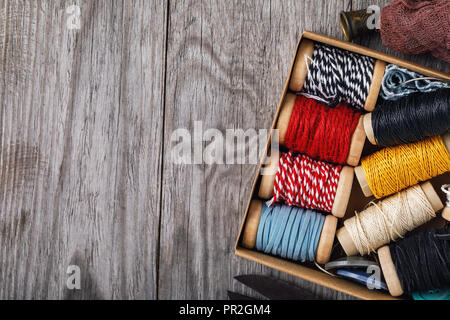 Bobine multicolori con filettature e strumenti per il lavoro di ricamo con copia spazio, vista dall'alto. Foto Stock