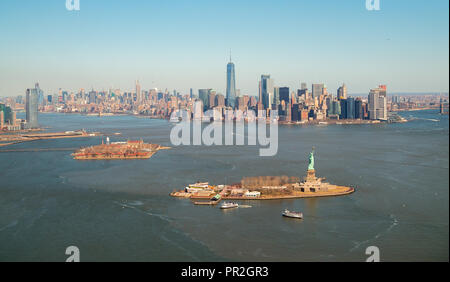 Libertà e Ellis isole e il centro di Manhattan si vede da un giro in elicottero sopra New York Bay Foto Stock