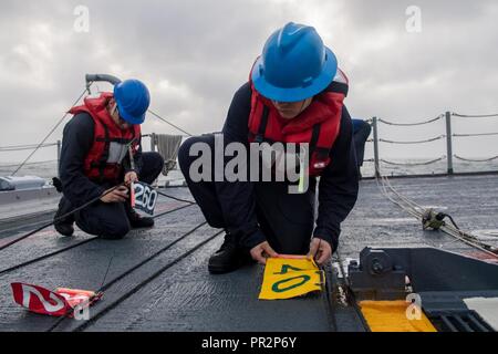 Flotta AREA DI OPERAZIONI (Luglio 22, 2017) Electronics tecnico di terza classe Brandon Fuls, da Dallas, e Electronics tecnico di terza classe Joshua Michel, da Los Angeles, preparare il telefono e la linea a distanza come Ticonderoga-class guidato-missili cruiser USS Princeton (CG 59) viene impostato a condurre a una ricostituzione in mare. Princeton è distribuito negli Stati Uniti Quinta Flotta area di operazioni a sostegno della sicurezza marittima operazioni destinate a rassicurare gli alleati e partner e preservare la libertà di navigazione e il libero flusso di commercio nella regione. Foto Stock