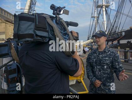 BOSTON (Luglio 23, 2017) marinaio Anthony giorno, assegnato alla USS Constitution, risponde alle domande sulla Costituzione durante un colloquio prima di Old Ironsides risale nell'acqua. Negli ultimi 26 mesi, Costituzione ha subito un esteso intervento di restauro che aiuterà a preservare l'America Nave di stato per molti decenni a venire. Foto Stock