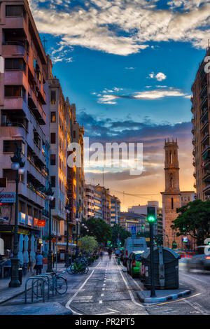 Una lunga esposizione tramonto sulla Calle de Jativa a Valencia in Spagna mostra auto e piste ciclabili (nomi commerciali modificate out) Foto Stock