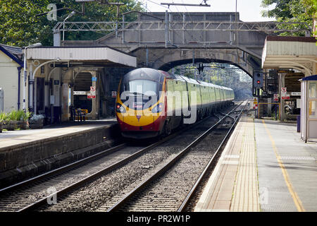 Alderley Edge, Cheshire, Inghilterra. una vergine British Rail Class 390 Pendolino voce per Londra passando per il villaggio di stazione ferroviaria Foto Stock