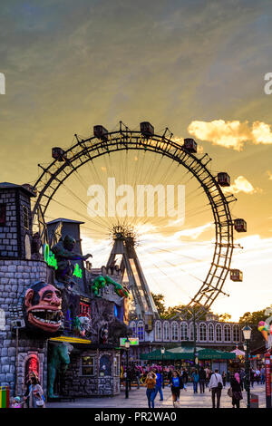 Wien, Vienna: Riesenrad (ruota panoramica Ferris, ruota gigante), creepy casa 'Geisterschloss' nel parco divertimenti Prater, Fiery sunset, 02. Leopoldstadt, Wien, Aus Foto Stock