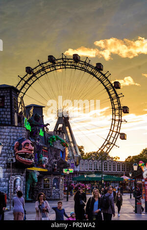 Wien, Vienna: Riesenrad (ruota panoramica Ferris, ruota gigante), creepy casa 'Geisterschloss' nel parco divertimenti Prater, Fiery sunset, 02. Leopoldstadt, Wien, Aus Foto Stock