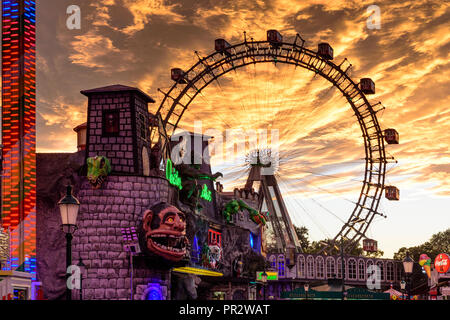 Wien, Vienna: Riesenrad (ruota panoramica Ferris, ruota gigante), creepy casa 'Geisterschloss' nel parco divertimenti Prater, Fiery sunset, 02. Leopoldstadt, Wien, Aus Foto Stock