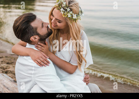 Sorridente elegante sposa e lo sposo a baciare sulla spiaggia Foto Stock