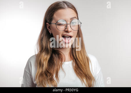 Divertenti ragazza carina a lampeggiare i suoi occhi con piacere. donna con espressione felice Foto Stock