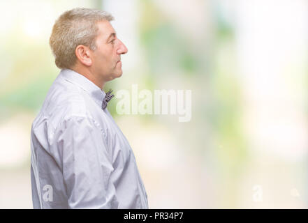 Bello il senior uomo che indossa il filtro bow tie su sfondo isolato guardando al lato, profilo relax posano con faccia naturale con sorriso sicuro. Foto Stock