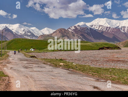 I ciclisti sulla strada del Pamir scendendo dal Pamir Mountains nel telecomando Alay Valley in Kirghizistan. Foto Stock