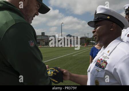 GREEN Bay, Wisconsin (28 luglio 2017) - David Robinson Jr., il comando Master Chief, USS Green Bay (LPD 20), presenta il Green Bay Packers capo allenatore Mike McCarthy, con un USS Baia Verde di nave tappo a sfera sul margine del Packers' campo pratica, durante il Green Bay/Fox Cities Navy settimana. Navy settimana programmi servono come NEGLI STATI UNITI Navy Il principale sforzo di divulgazione in aree del paese che la mancanza di una significativa presenza della Marina Militare, aiutando gli americani a capire che il loro Marina è distribuito in tutto il mondo, circa l'orologio, pronto a difendere l'America in tutti i tempi. Foto Stock