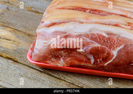 Pezzi di materie bistecche bistecca di carne di maiale con sfondo in legno in stile rustico Foto Stock