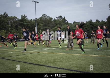 Stati Uniti Marines con stazione di reclutamento di Portsmouth eseguire ai partecipanti degli sport La Leadership Academy - Boston Soccer programma attraverso una dinamica warm-up session a ribalta calci facility in Taunton, Massachusetts, luglio 22, 2017. L'Accademia è un programma gratuito offerto alla high school atleti per aumentare le loro abilità di calcio e di acquisire la conoscenza di leadership dal locale della Marina reclutatori. Foto Stock