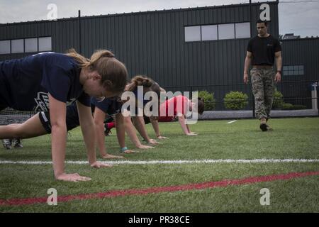 Stati Uniti Marine Corps Sgt. Steven Baez conta il push-up ripetizioni dei partecipanti della Leadership Sports Academy - Boston Soccer programma a ribalta calci facility in Taunton, Massachusetts, luglio 22, 2017. L'Accademia è un programma gratuito offerto alla high school atleti per aumentare le loro abilità di calcio e di acquisire la conoscenza di leadership dal locale della Marina reclutatori. Baez è un selezionatore a domicilio con il reclutamento di sottostazione Brockton, messa. Foto Stock