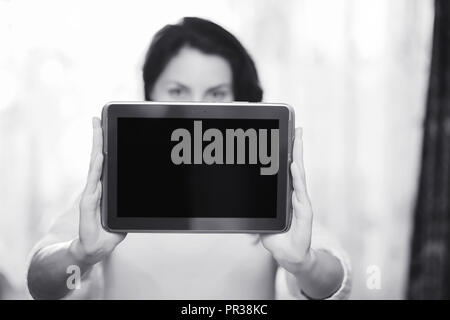 La ragazza è in possesso di una compressa. La ragazza ha un computer con un SCR Foto Stock