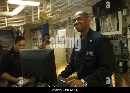 Oceano Pacifico - Sottufficiali di seconda classe Stephen Granam, una nave veterani con l'America anfibio gruppo pronto, mans il registro di cassa presso la nave del negozio a bordo dell'assalto anfibio nave USS America (LHA 6), 22 luglio 2017. Xv Marine Expeditionary Unit e America pronto anfibio gruppo Team attualmente distribuito al 3°, 5° e 7° flotta aree di responsabilità come una risposta in caso di crisi e di forza di emergenza. Foto Stock