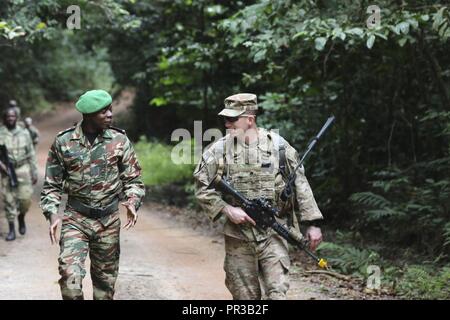 Stati Uniti Esercito Capt. Calvin L. Torbert, diritto, comandante di una società, 1° Battaglione, 327Reggimento di Fanteria, 101st Airborne Division (Air Assault), mantiene il passo lungo con Repubblica Gabonese Marine Nationale 1Lt. Zengue Boucah Pierre Cedric Marvin, su un terreno a piedi attraverso una foresta pluviale warfare training center a Libreville, Gabon, luglio 26, 2017. La formazione condotta era parte della durata di una settimana nazione partner esercizio giudizioso di attivazione "17-2. Foto Stock