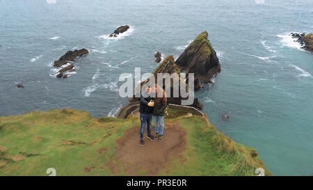 Coppia giovane prende un selfie a Dunquin Pier - Irlanda antenna filmato di volo Foto Stock
