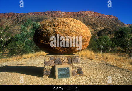 Il Reverendo John FLYNN GRAVE (fondatore del Royal Flying Doctor Service) Territorio del Nord, l'Australia. Uno dei Devil's marmi è stato impiegato come un marcatore. Foto Stock