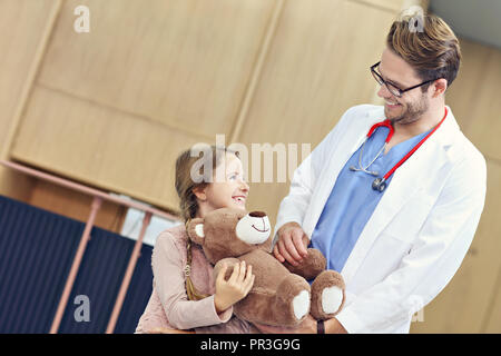 Medico accogliente bambina in clinica Foto Stock