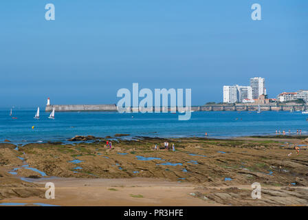 Faro sul pontile e rocce sulla spiaggia di Les Sables D Olonne in Vandea Francia Foto Stock