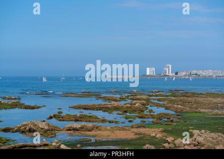 Faro sul molo con barca a vela e rocce a Les Sables D Olonne in Vandea Francia Foto Stock